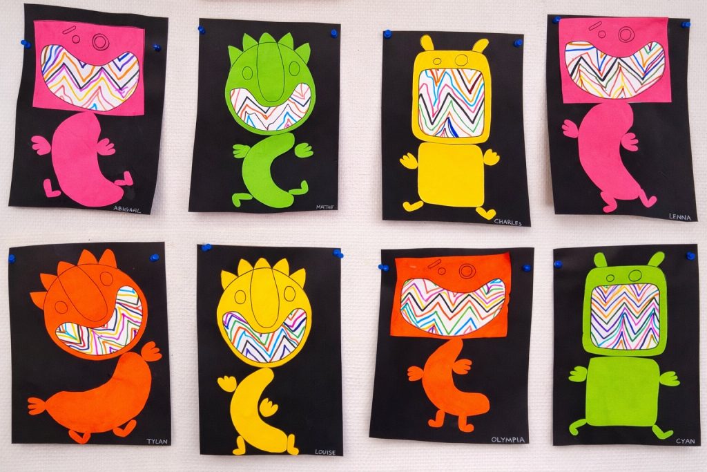 Détail de monstres en papier avec dents en zigzag tracées au feutre – activité de graphisme en grande section.